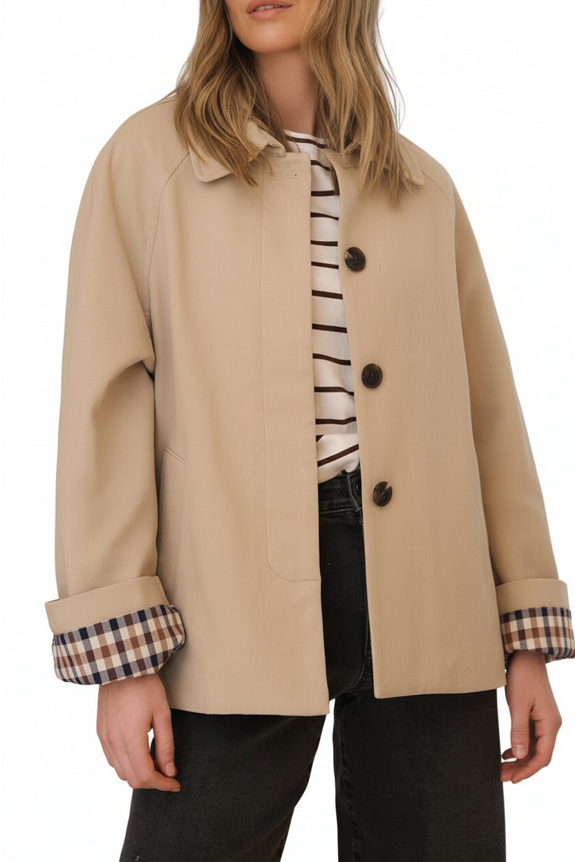 Neutral parchement and plaid short trench coat for your on-the-go customer.  Classic plaid lining and folding sleeves, pockets and buttons with hidden placket creates a timeless and versatile look on any body type.